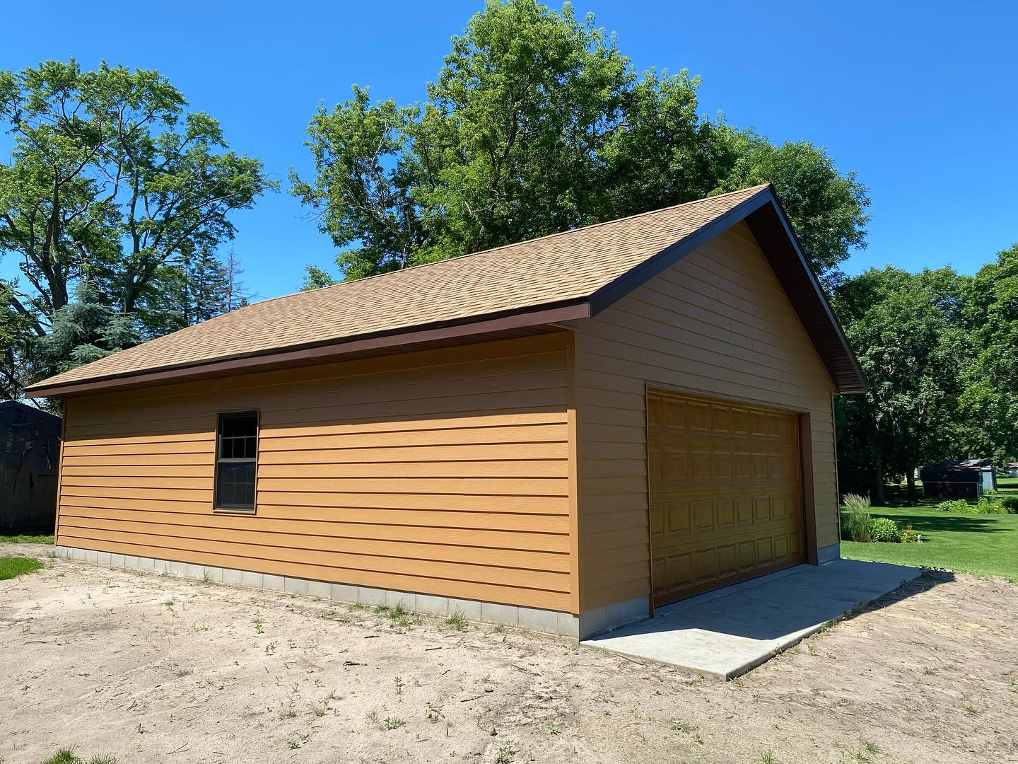 Side profile of a new two-car garage with shingle roof in St. Cloud, MN