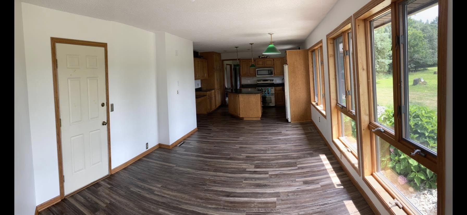 Interior remodel with new wood-look flooring and a sunlit dining area off the kitchen