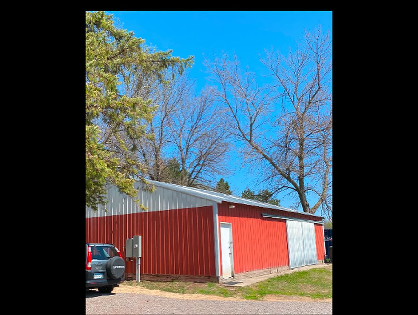 Red metal shop building with sliding door built by Brudwick Builders