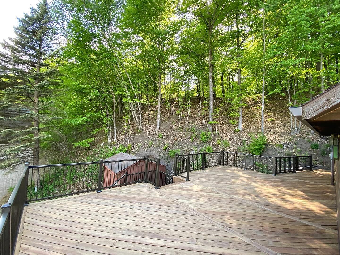 Multi-level wood deck stepping down into a wooded hillside